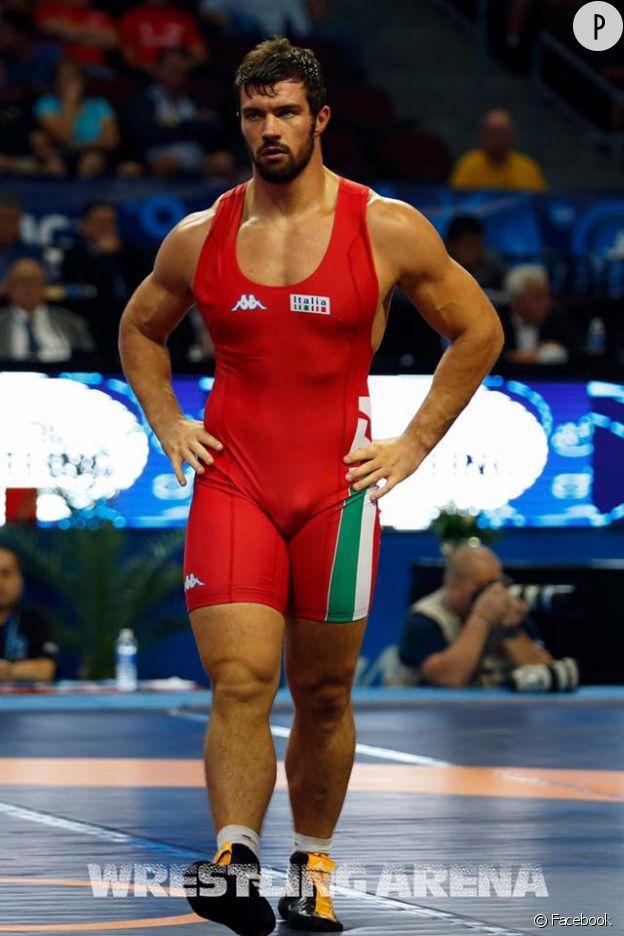 a man standing on top of a wrestling ring wearing a red suit and yellow socks