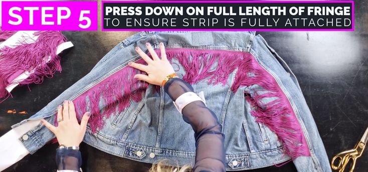 two girls touching each other's hands on a jean jacket with pink fringes