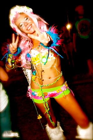 a woman with pink hair is posing for the camera while wearing colorful clothing and boots