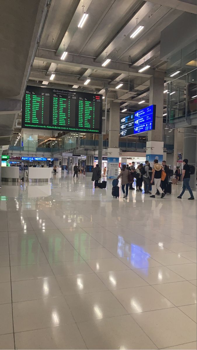 many people are walking through an airport terminal