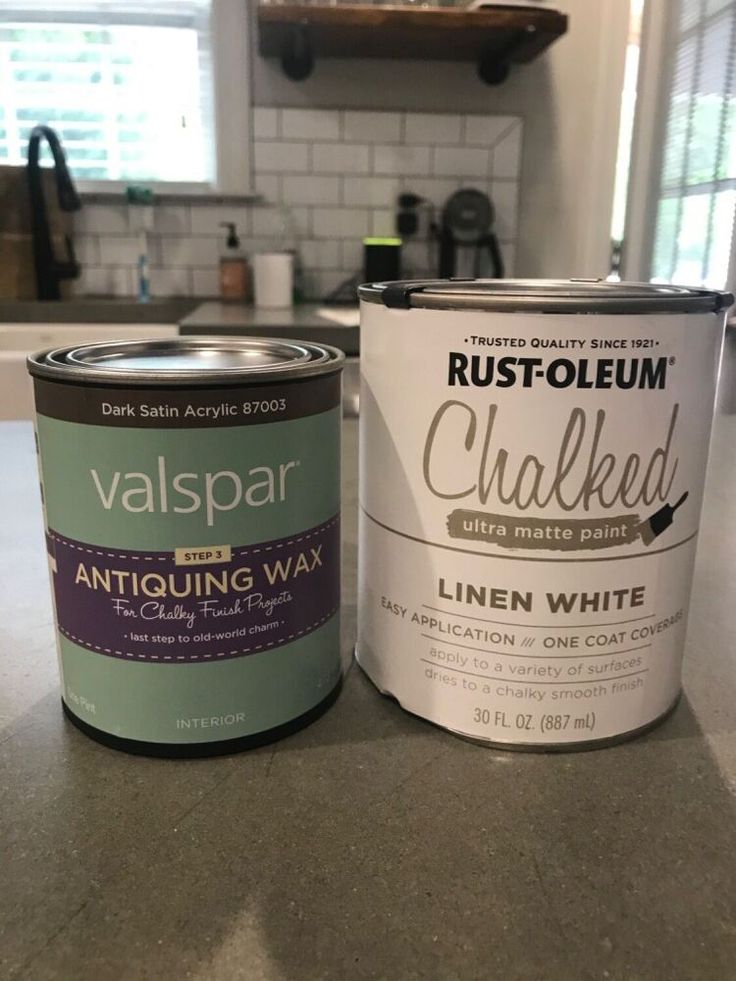 two cans of white paint sitting on top of a kitchen counter next to each other