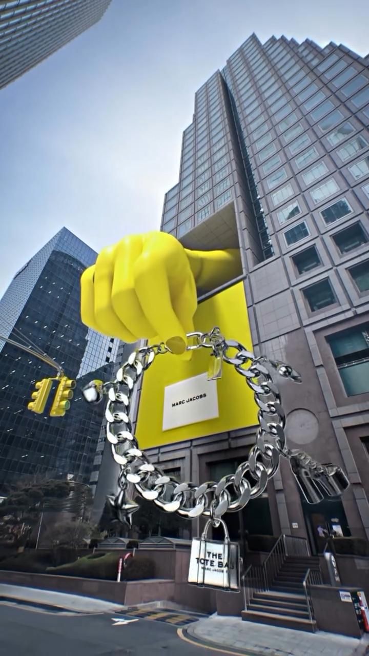 a large yellow object is chained to a metal chain in front of a tall building