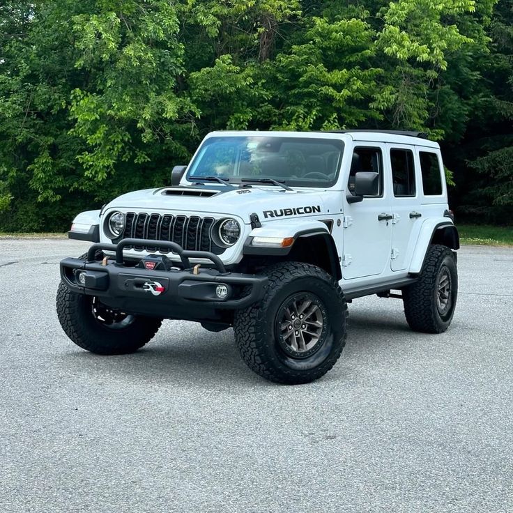 a white jeep is parked in a parking lot