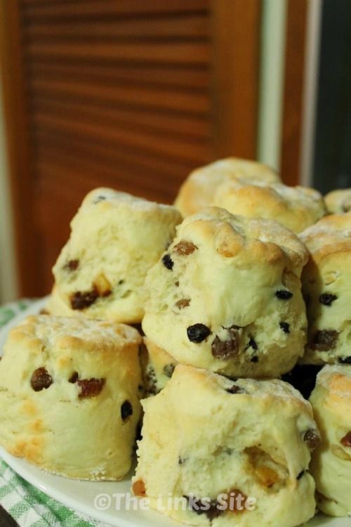 a pile of chocolate chip cookies sitting on top of a blue and white plate filled with muffins