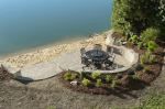 an aerial view of a picnic table on the side of a hill overlooking a body of water