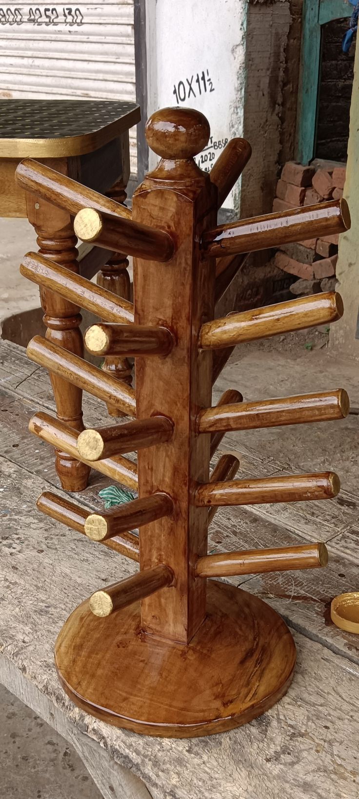 a wooden rack with lots of coins in it on a table next to a building