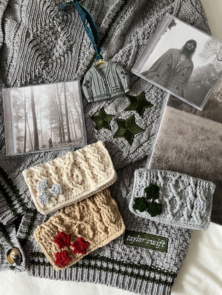 an assortment of crocheted items are laid out on a blanket, including photos and magnets