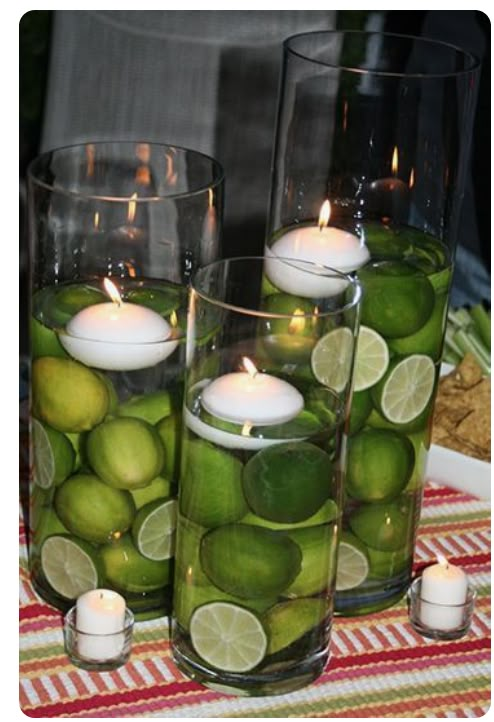 limes and candles are in glass vases on a table