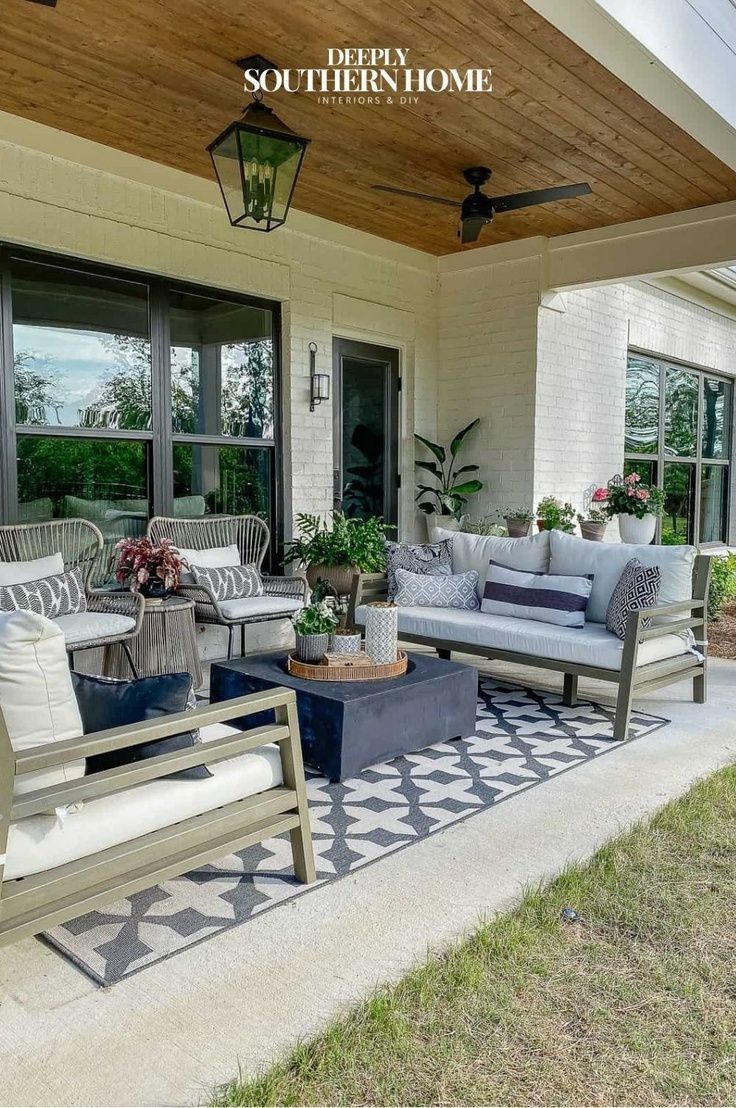 the front porch is decorated with furniture and potted plants