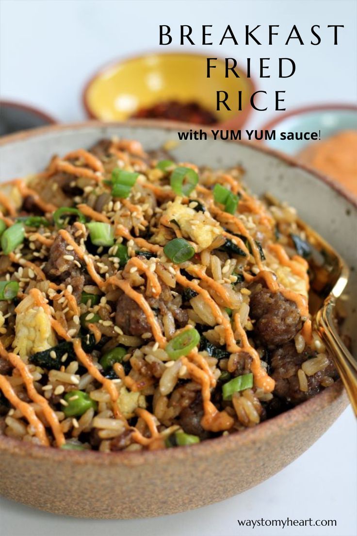 a bowl filled with fried rice, meat and veggies next to a spoon