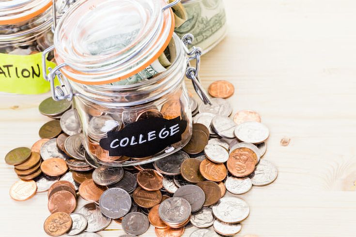 a jar filled with coins sitting on top of a table next to a sign that reads college