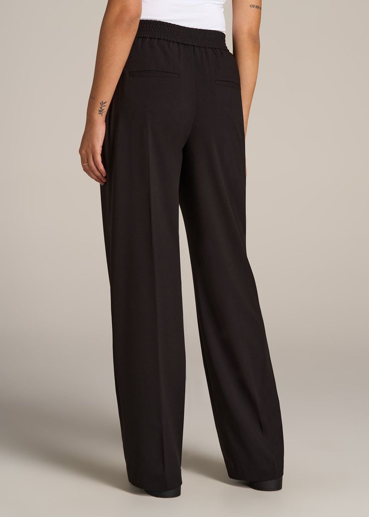 About Our Flat Front Wide Leg Dress Pants for Tall Women Ultra-flattering and easy to wear, these women's tall dress pants are a closet essential. They feature a smooth front with a contoured waistband for a complimentary finish. Pleated accents at the front and back elongate your legs and make them easy to wear from the desk to dinner. Built with a stretch-infused polyester-viscose blend, these pants for tall women offer the sleek feel of a suit with the comfort of a lounge pant. An elastic at Pants For Tall Women, Tall Dress, Women In Black, Tall Dresses, Wide Leg Dress Pants, Closet Essentials, Tall Women, Arm Sleeve, Lounge Pants