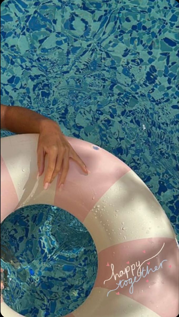 a woman in a swimming pool with an inflatable ring around her neck and hand on top