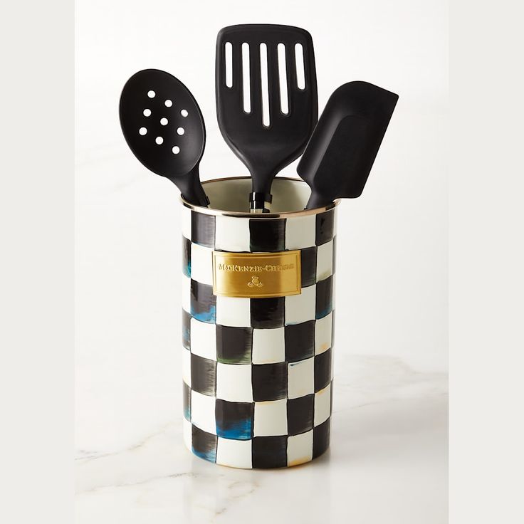 three black and white kitchen utensils in a checkered cup