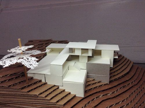 a model of a house sitting on top of a pile of cardboard