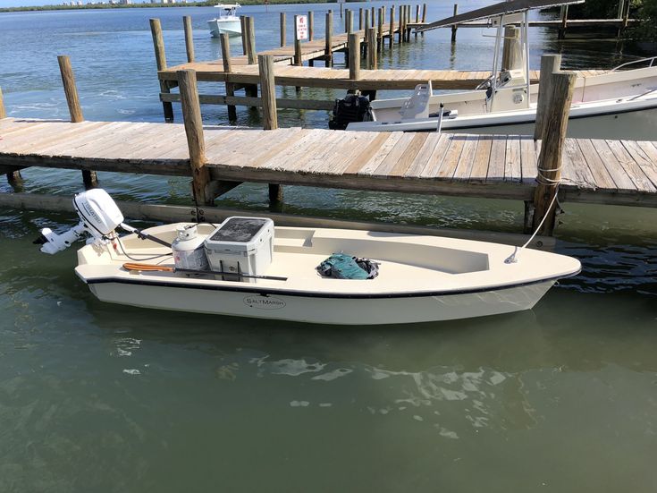 a small white boat docked at a dock