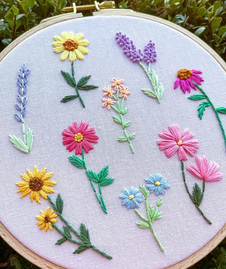 a close up of a embroidery on a piece of cloth with flowers in the middle