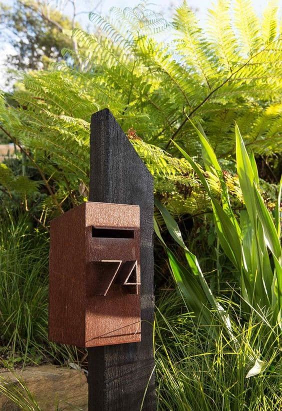 a wooden sculpture with the number seven on it's side in front of some plants