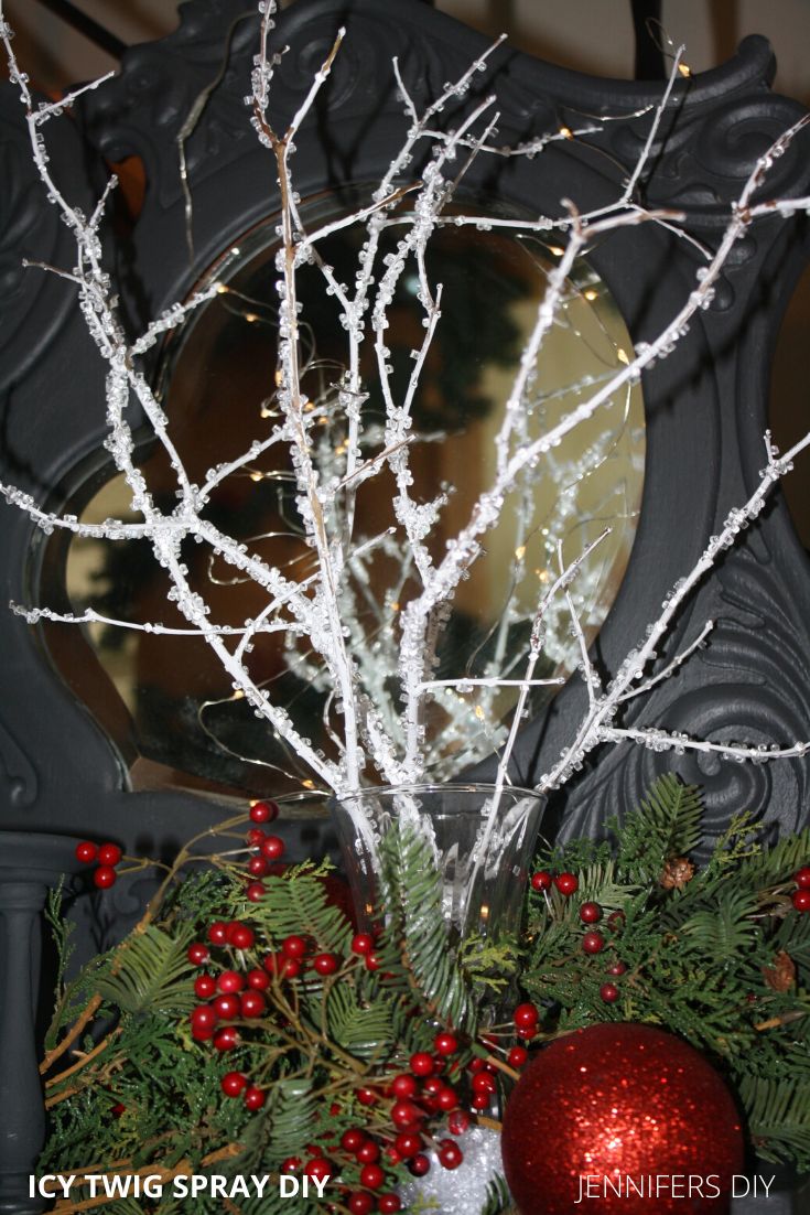 a christmas wreath with white branches and red berries in front of a black grandfather clock