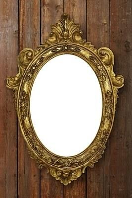 an ornate gold framed mirror on a wooden wall