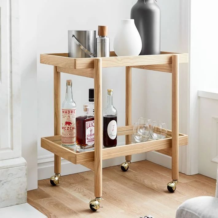 a bar cart with bottles and glasses on it