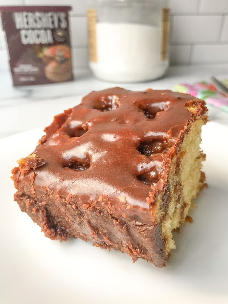 a piece of cake sitting on top of a white plate next to a glass of milk