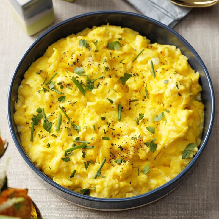 a blue bowl filled with mashed potatoes on top of a table