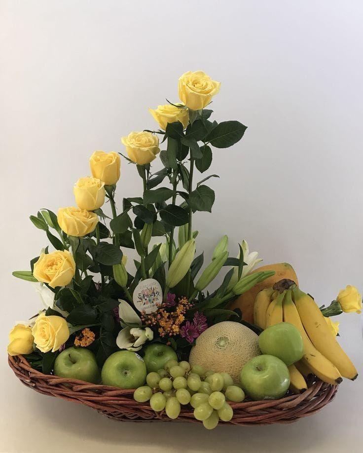 a basket filled with lots of fruit and flowers