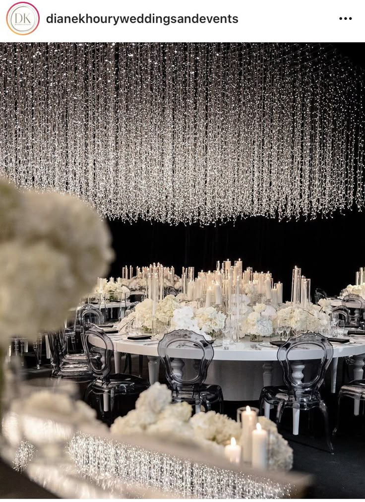 a table with white flowers and chandelier hanging from the ceiling