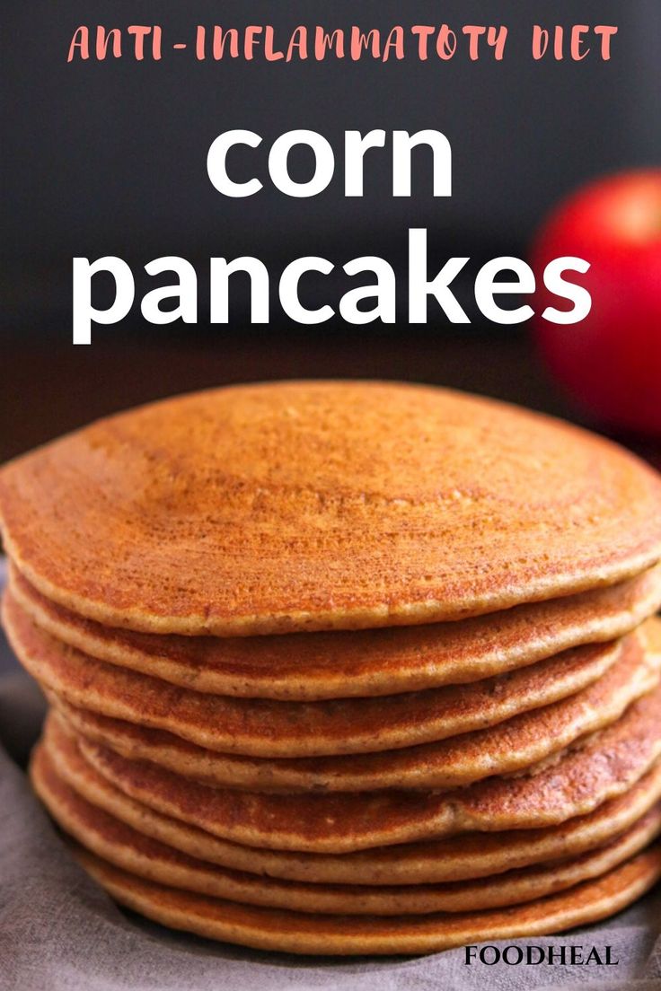 a stack of pancakes sitting on top of a table next to an apple and cinnamon