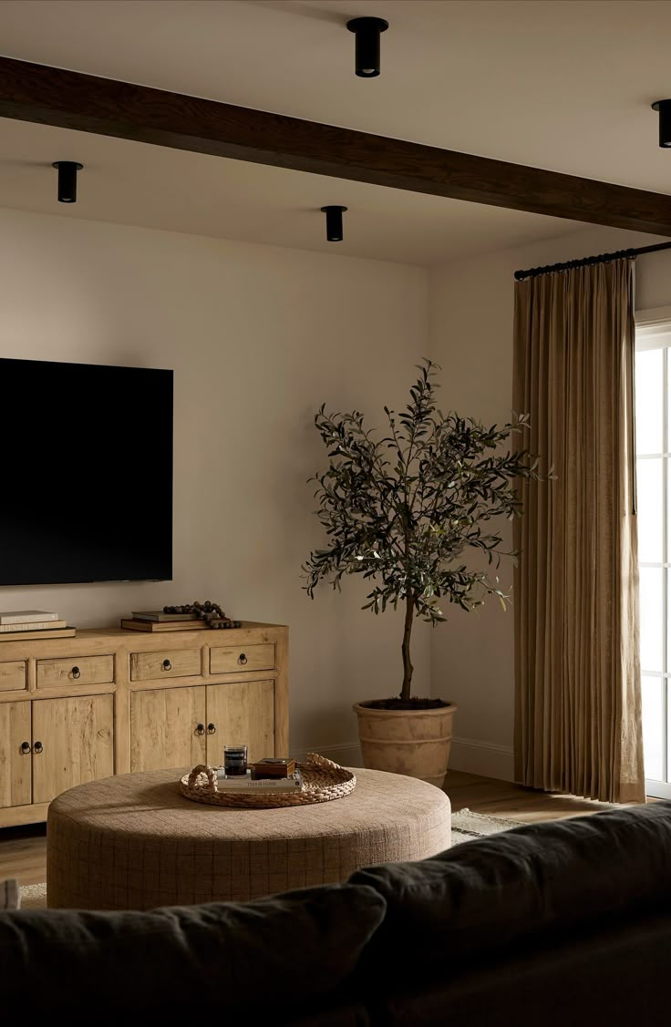 a living room with a couch, coffee table and television on top of the wall