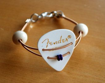 a white guitar pick bracelet on a wooden table