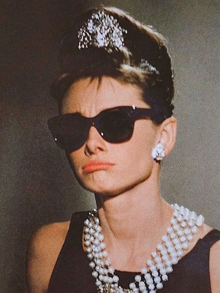 a woman with sunglasses and pearls on her head