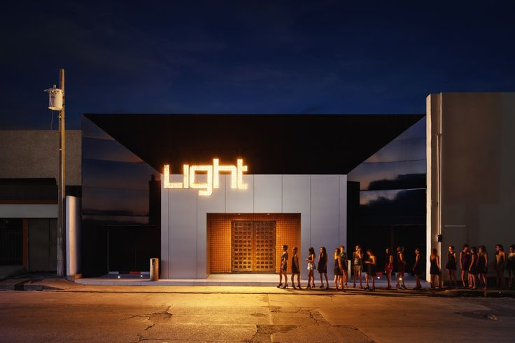 a group of people standing in front of a building with the word light on it