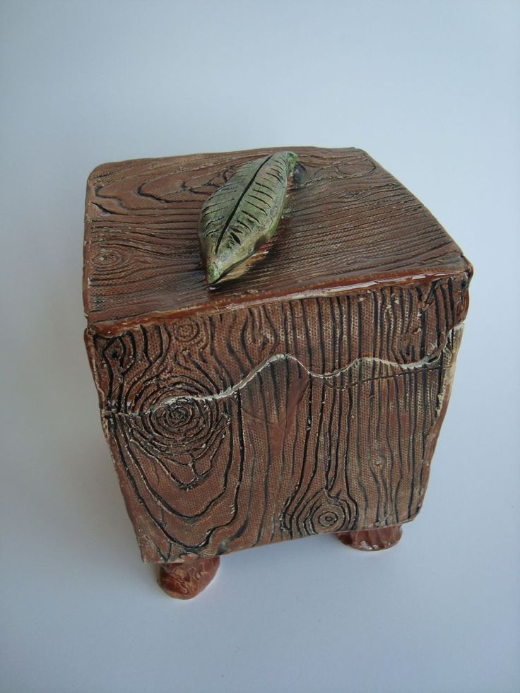 a wooden box with a leaf on top