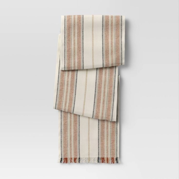 an orange and white striped scarf hanging on a wall