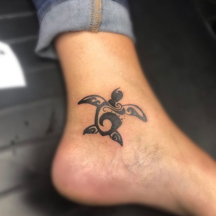 a tattoo on the foot of a person with an ornament in the shape of a turtle