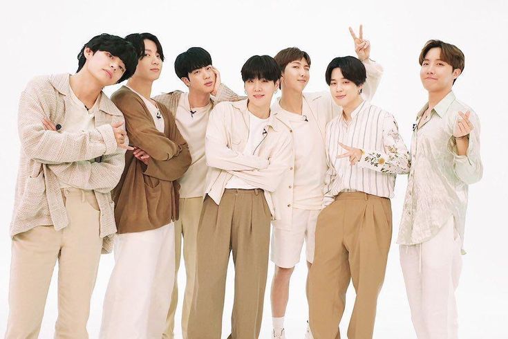 a group of young men standing next to each other in front of a white background