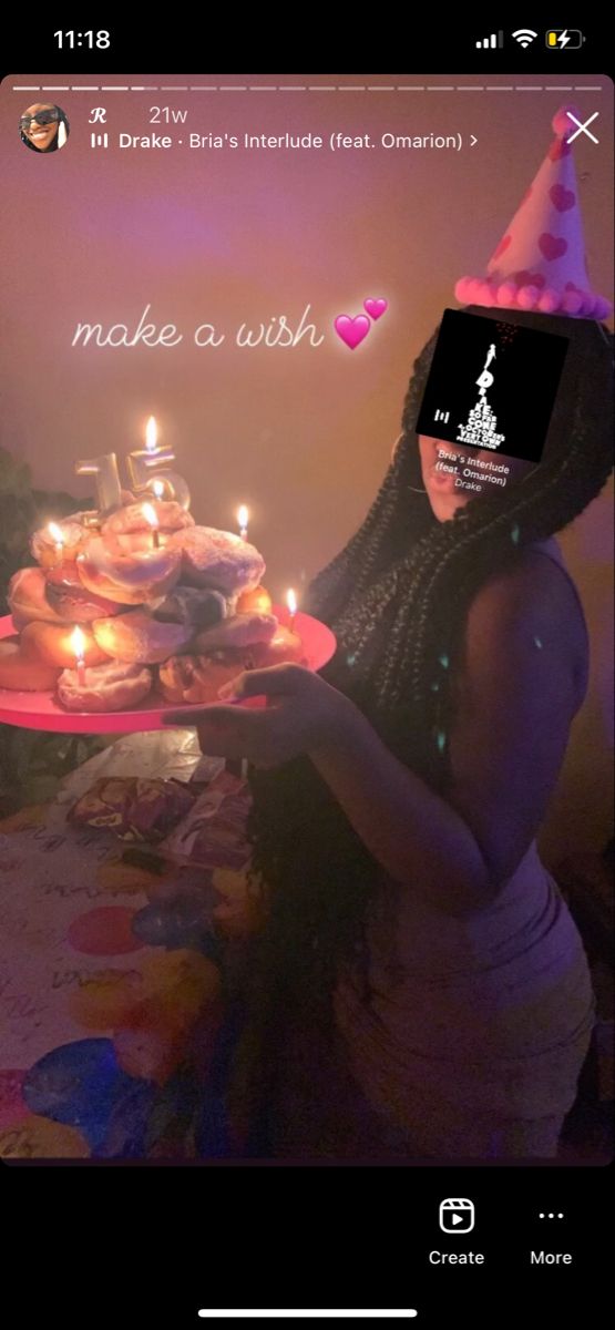 a woman holding a cake with lit candles on it in front of a birthday card