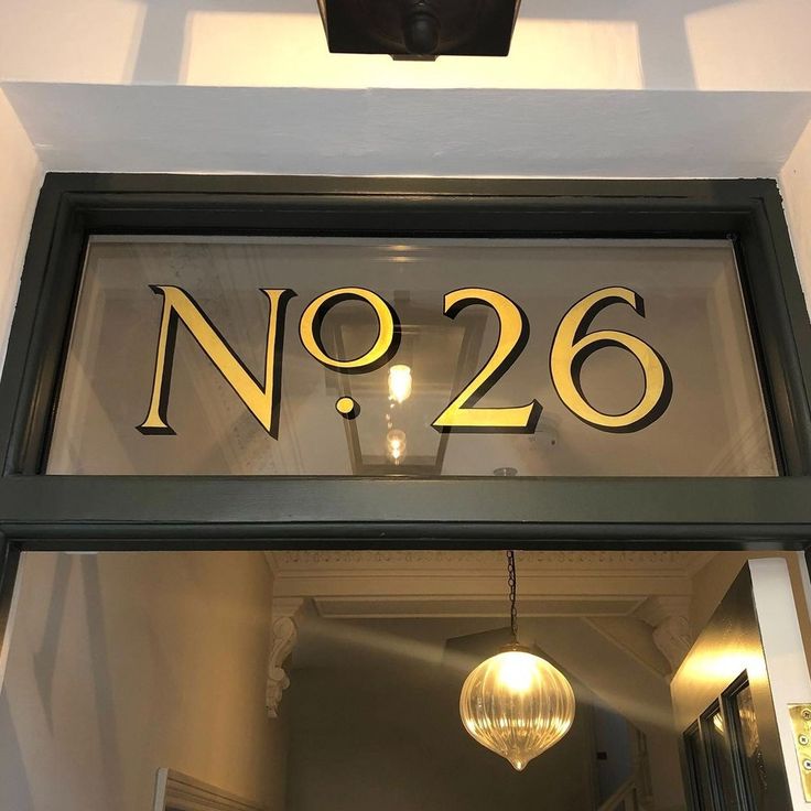 a sign that reads no 26 hanging from the side of a building's door