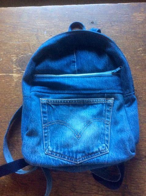 a small blue backpack sitting on top of a wooden table