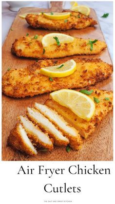 air fryer chicken cutlets on a cutting board with lemons and parsley