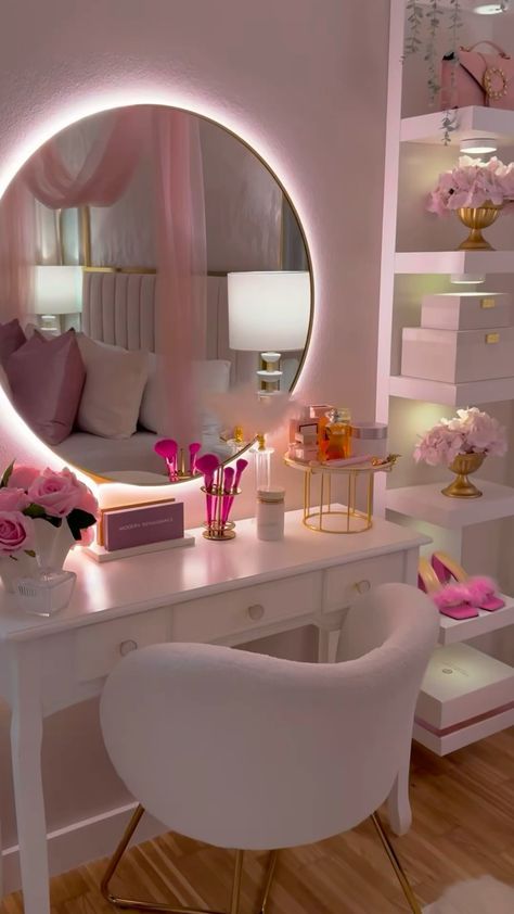 a white desk topped with a mirror next to a chair and table covered in pink flowers