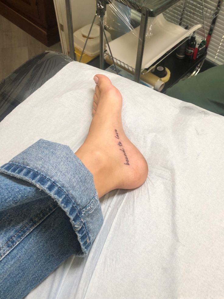 a person's foot with the word love tattooed on it sitting in a hospital bed