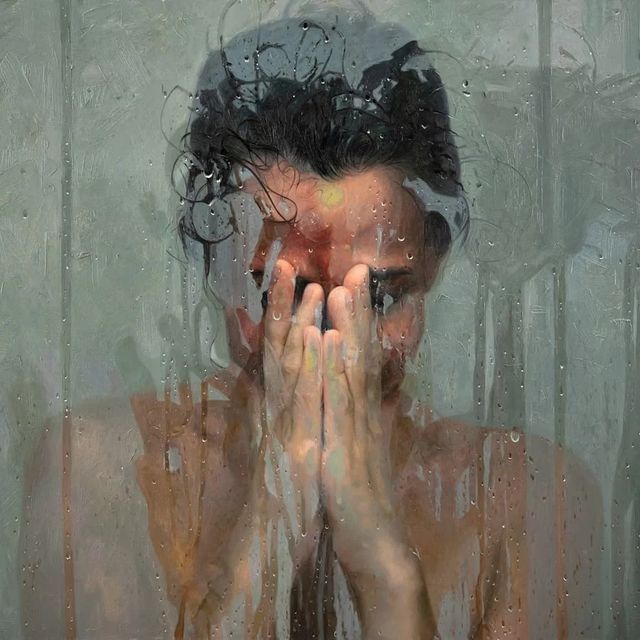 a woman holding her hands to her face in front of a rain soaked glass window