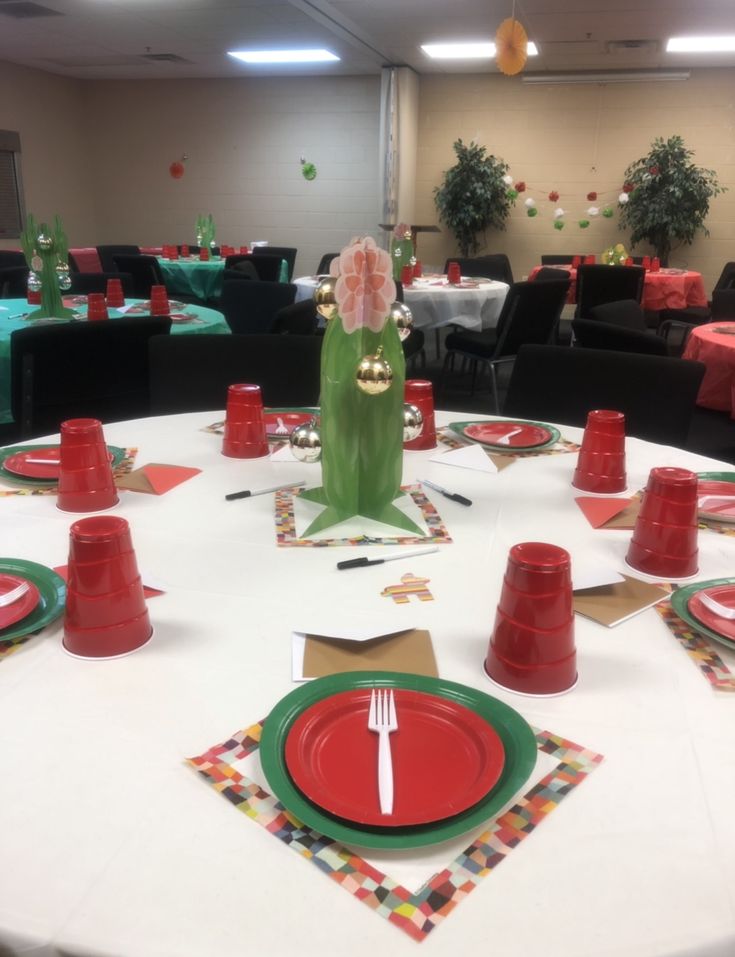 a white table topped with red and green plates