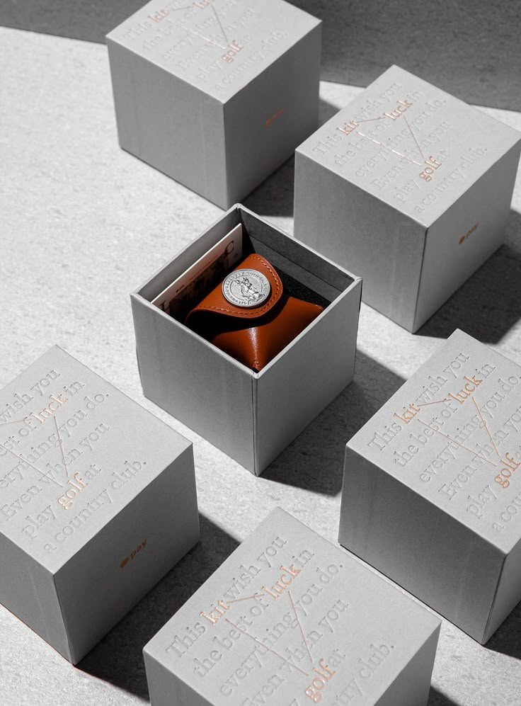 six boxes with different types of items in them on the ground, including an orange and white watch