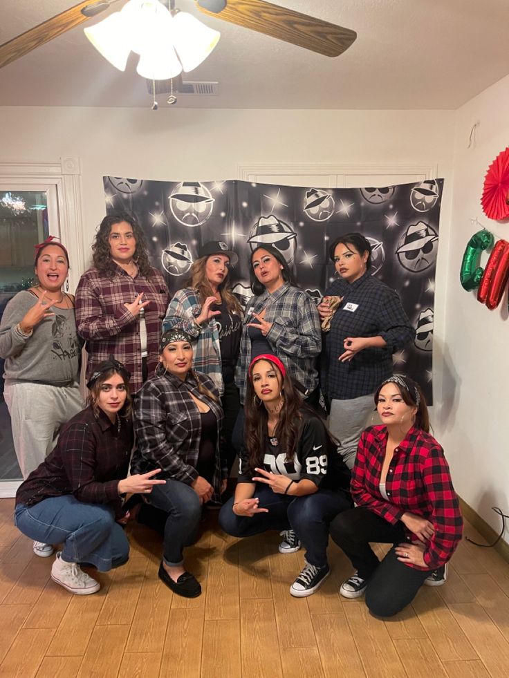 a group of people posing for a photo in front of a wall with christmas decorations