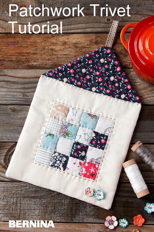 the patchwork trivet is next to some thread and spools on a wooden table