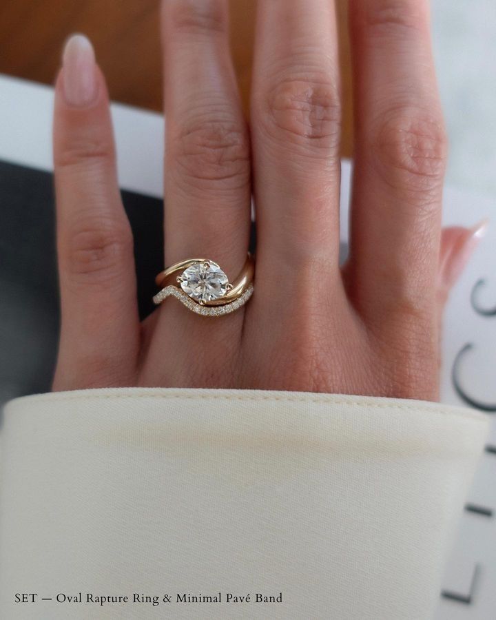 a woman's hand with a diamond ring on top of her finger and the other hand holding it